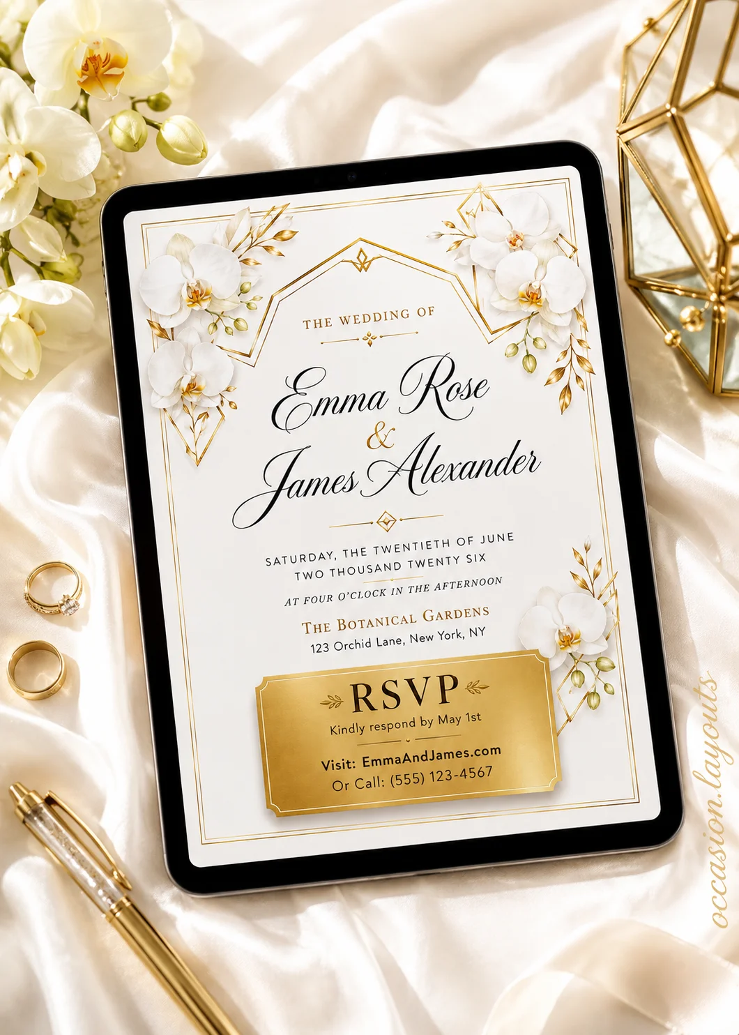 Gold geometric wedding invitation with white orchids, gold accents, and elegant script in a satin flat-lay bridal arrangement.